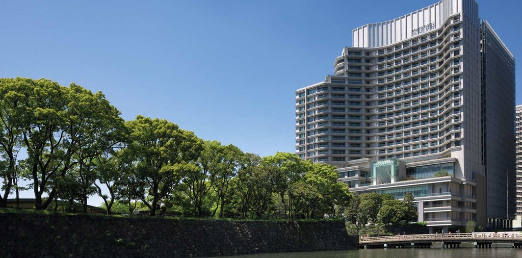 Luxurious modern hotel lobby with elegant marble floors, contemporary Japanese design, and sweeping city views of downtown Tokyo skyline