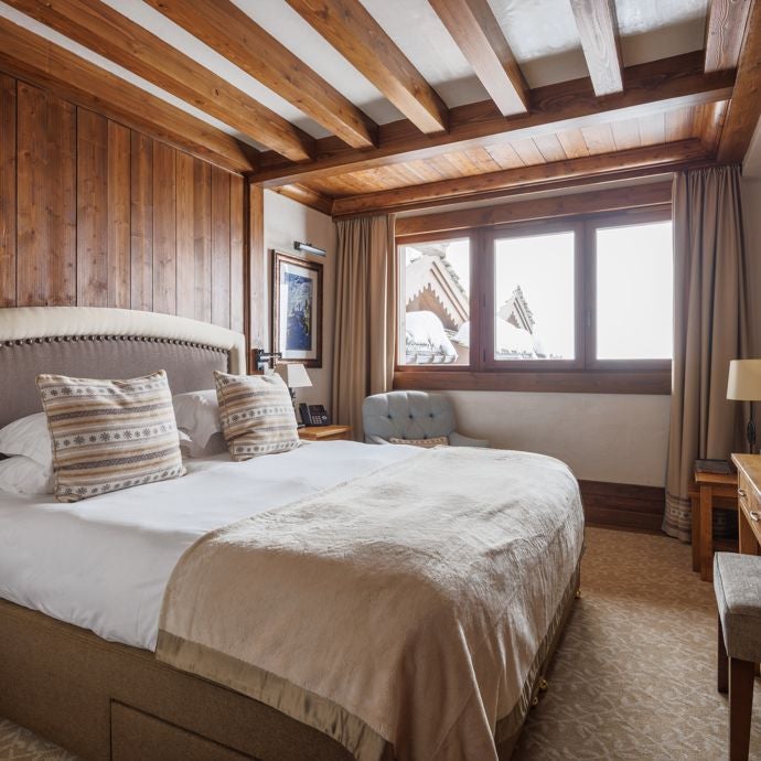 Luxurious alpine hotel room with expansive valley view, modern minimalist decor, soft neutral tones, and floor-to-ceiling windows showcasing mountain landscape