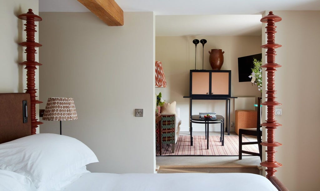 Elegant wood-paneled suite with soft cream linens, plush armchair, and panoramic countryside view at Grove of Narberth's luxurious Lovage room