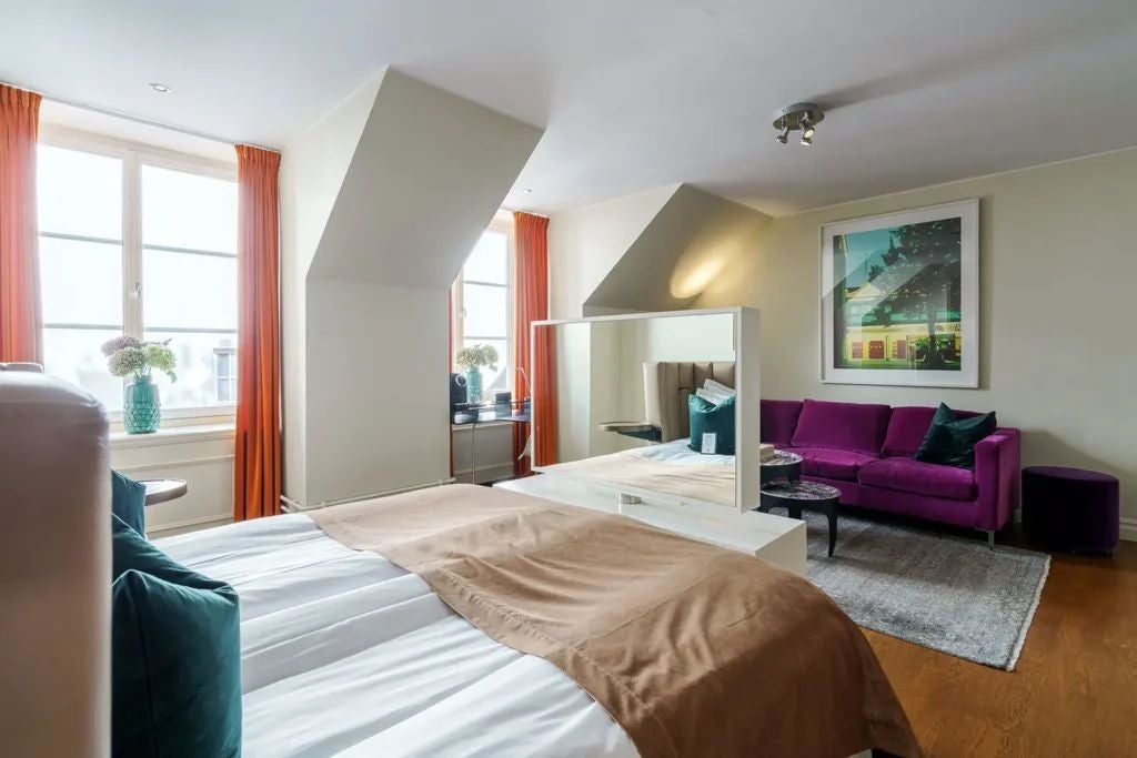 Elegant superior hotel room at Berns Hotel, featuring plush king bed, modern wooden floors, neutral color palette, and city-inspired sophisticated decor