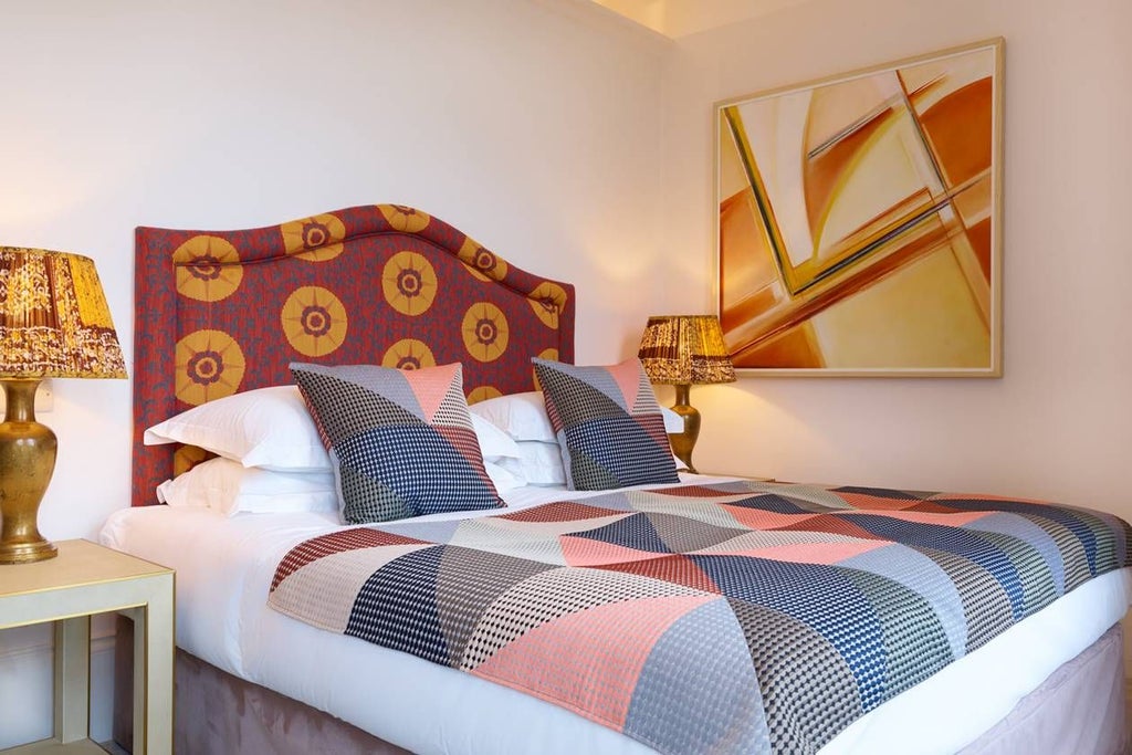 Luxurious king bedroom with plush bedding, elegant wooden furniture, soft neutral tones, and floor-to-ceiling windows overlooking scenic UK landscape at The Bird hotel