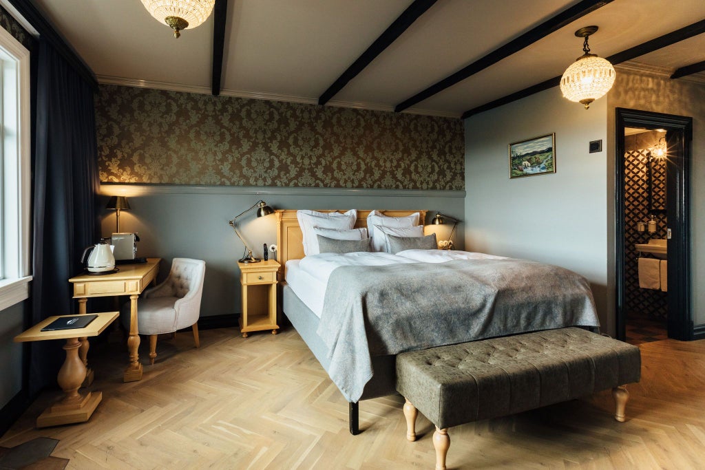 Spacious Icelandic luxury hotel room with elegant wooden furnishings, large windows overlooking scenic landscape, plush king-sized bed, and modern Nordic design elements