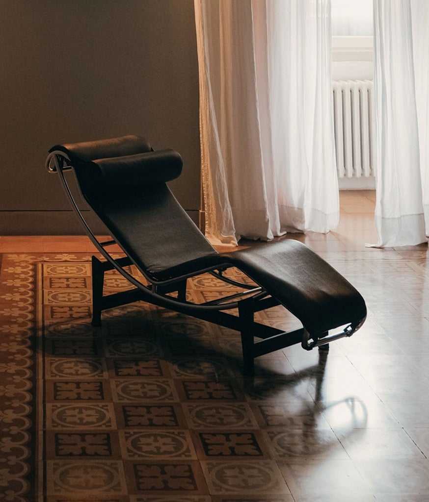 Elegantly designed historic Italian suite with vaulted ceilings, minimalist antique furnishings, and pale stone walls in soft natural light