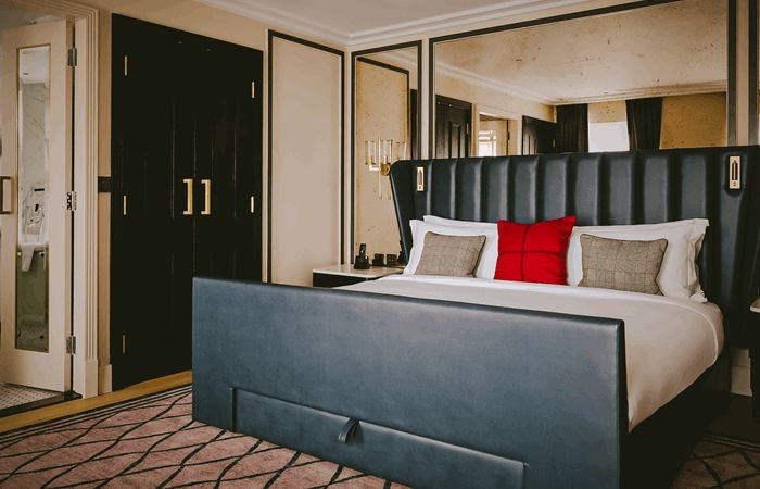 Luxurious Skylight Suite at the Mayfair Townhouse, featuring elegant modern decor, plush king bed, and soft natural light streaming through expansive skylight window