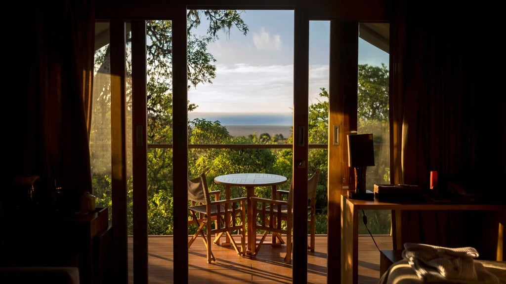 Luxurious safari tent at Galapagos Safari Camp with canvas walls, wooden deck, and panoramic views of rugged Ecuadorian landscape at sunset