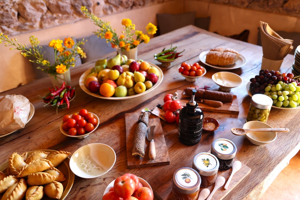 People enjoying artisanal olive oil tasting under rustic wooden pergola, surrounded by olive groves and luxury picnic spread in rural Spain