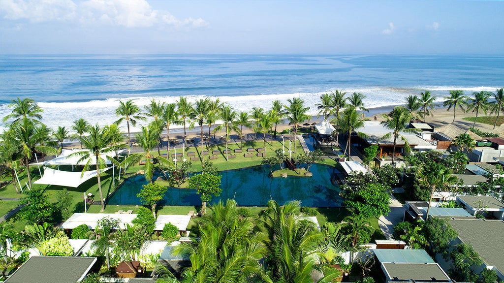 Luxurious infinity pool overlooking lush tropical jungle at Samaya resort Bali, with traditional Balinese architecture and palm trees