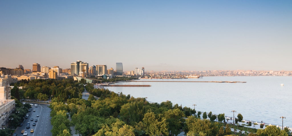 Opulent beige hotel tower with ornate Beaux-Arts architecture featuring grand balconies, arched windows and waterfront views of the Caspian Sea