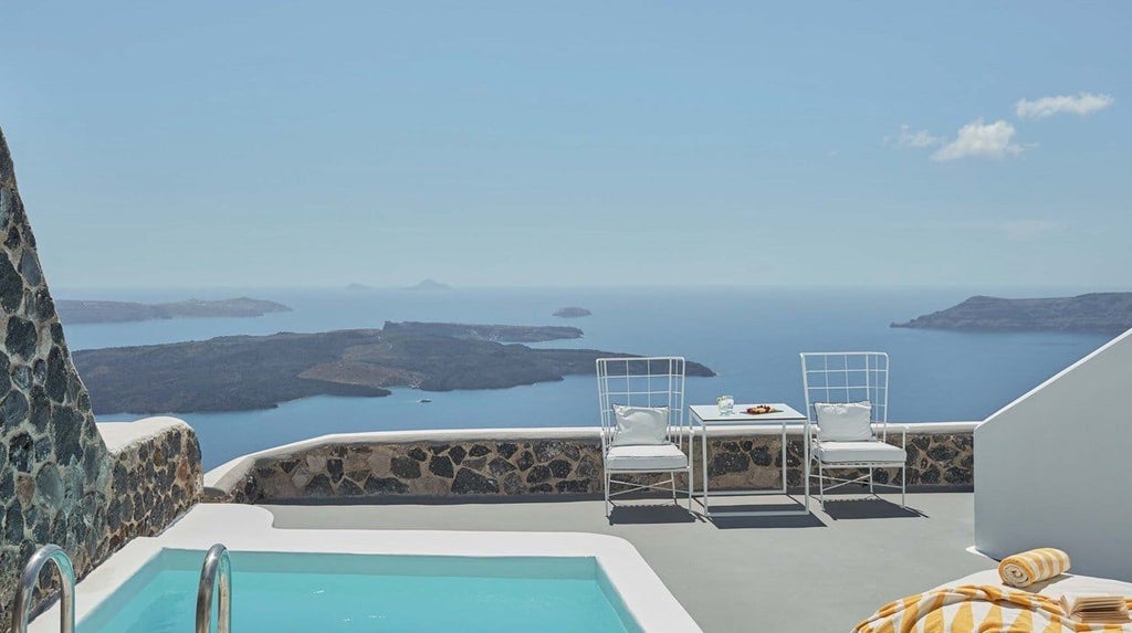 Luxurious white-washed master pool suite with private infinity pool overlooking Aegean Sea, featuring minimalist Cycladic design and stunning sunset panorama in Santorini, Greece