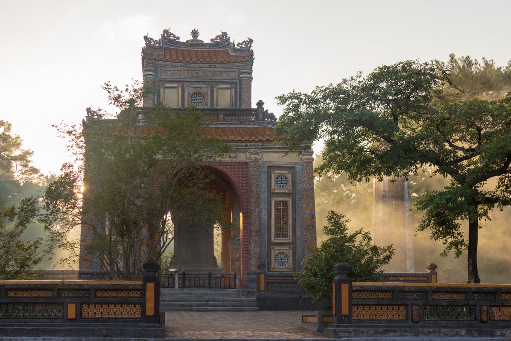 Luxurious Vietnamese tour exploring Hue's imperial citadel, featuring elegant traditional architecture, vibrant silk robes, and serene landscapes of central Vietnam's historic royal city.