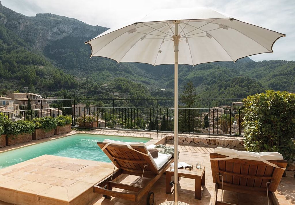 Elegant suite at La Residencia features a private balcony, mountain views, antique furnishings, and Mediterranean-inspired decor in warm tones