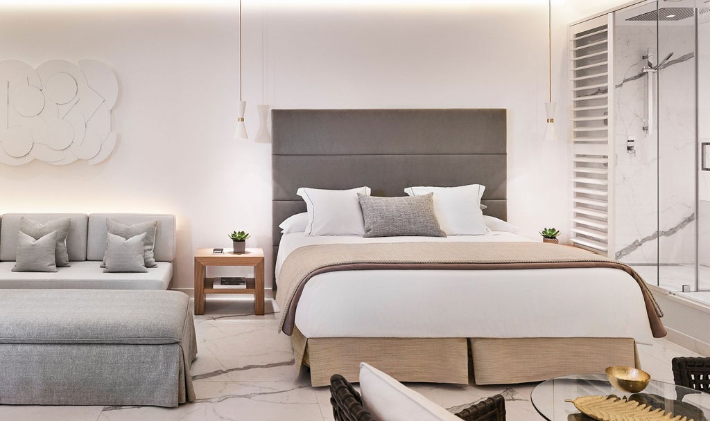 Elegant Deluxe Room at Nobu Hotel Marbella with minimalist design, crisp white linens, modern furnishings, and panoramic coastal views of Spanish landscape