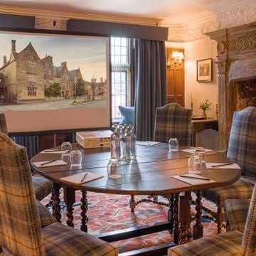 Elegant cosy double room at The Lygon Arms, featuring traditional British decor with plush bedding, rich wooden furniture, and soft neutral tones