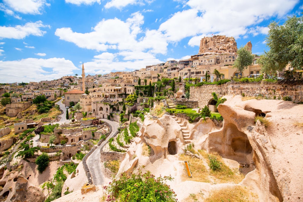 Dramatic sunrise over Cappadocia, Turkey with dozens of colorful hot air balloons floating above unique rock formations and valleys