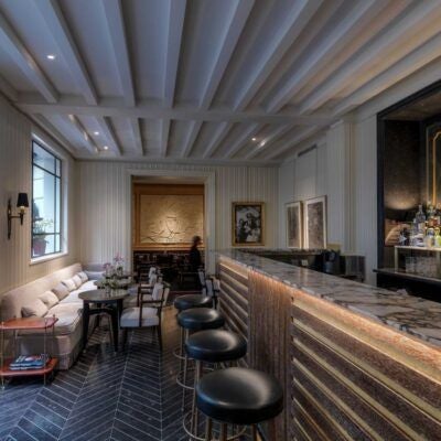 Elegant junior suite balcony at luxury boutique hotel in Rome, featuring plush seating, soft neutral tones, and scenic Italian architectural backdrop at sunset