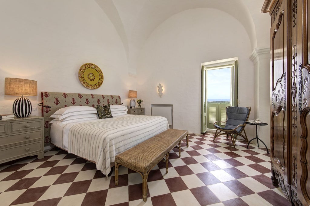 Historic white Puglian masseria with vaulted buildings nestled among olive groves, blooming bougainvillea, overlooking Adriat