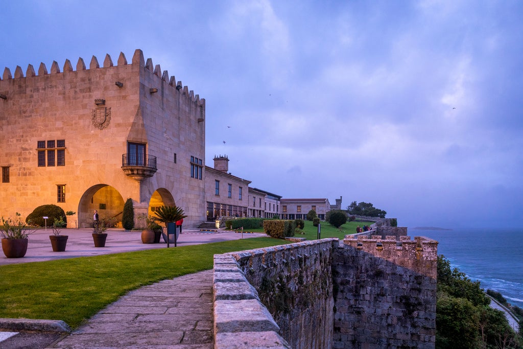 Historic stone fortress hotel overlooking the Atlantic Ocean, featuring medieval architecture with towers and sweeping coastal views