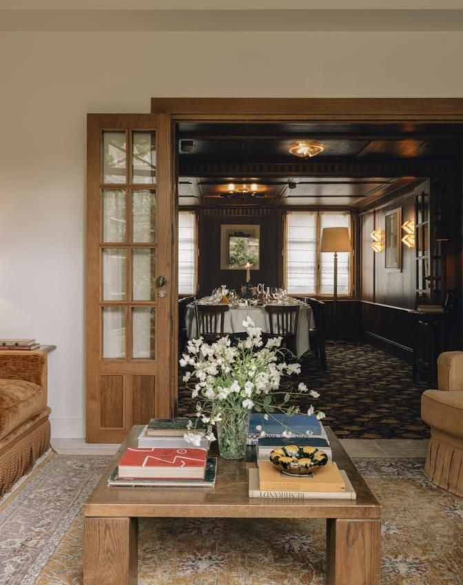 Elegant Parisian suite with rich navy blue walls, ornate golden mirror, plush white bed, and sophisticated French art deco design elements