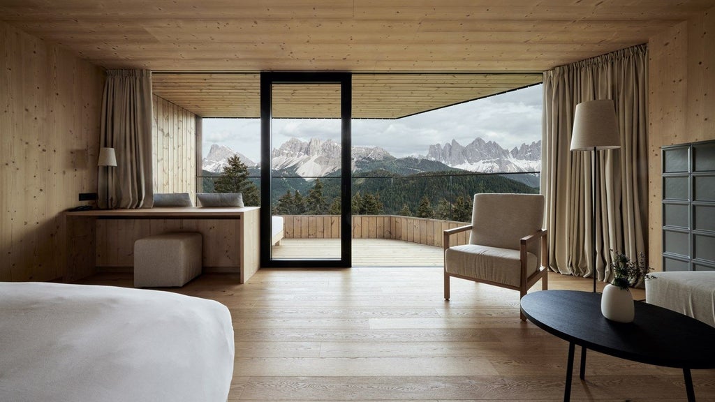 Luxury mountain resort nestled in Italian Dolomites with modern glass facade, infinity pool overlooking snow-capped alpine peaks at sunset