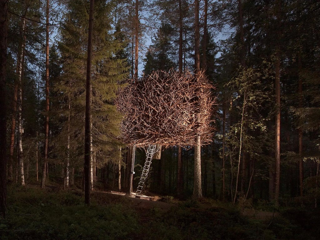 Suspended mirrored treehouse cabin nestled in snowy Swedish forest, reflecting surrounding pine trees and winter landscape with minimalist architectural design