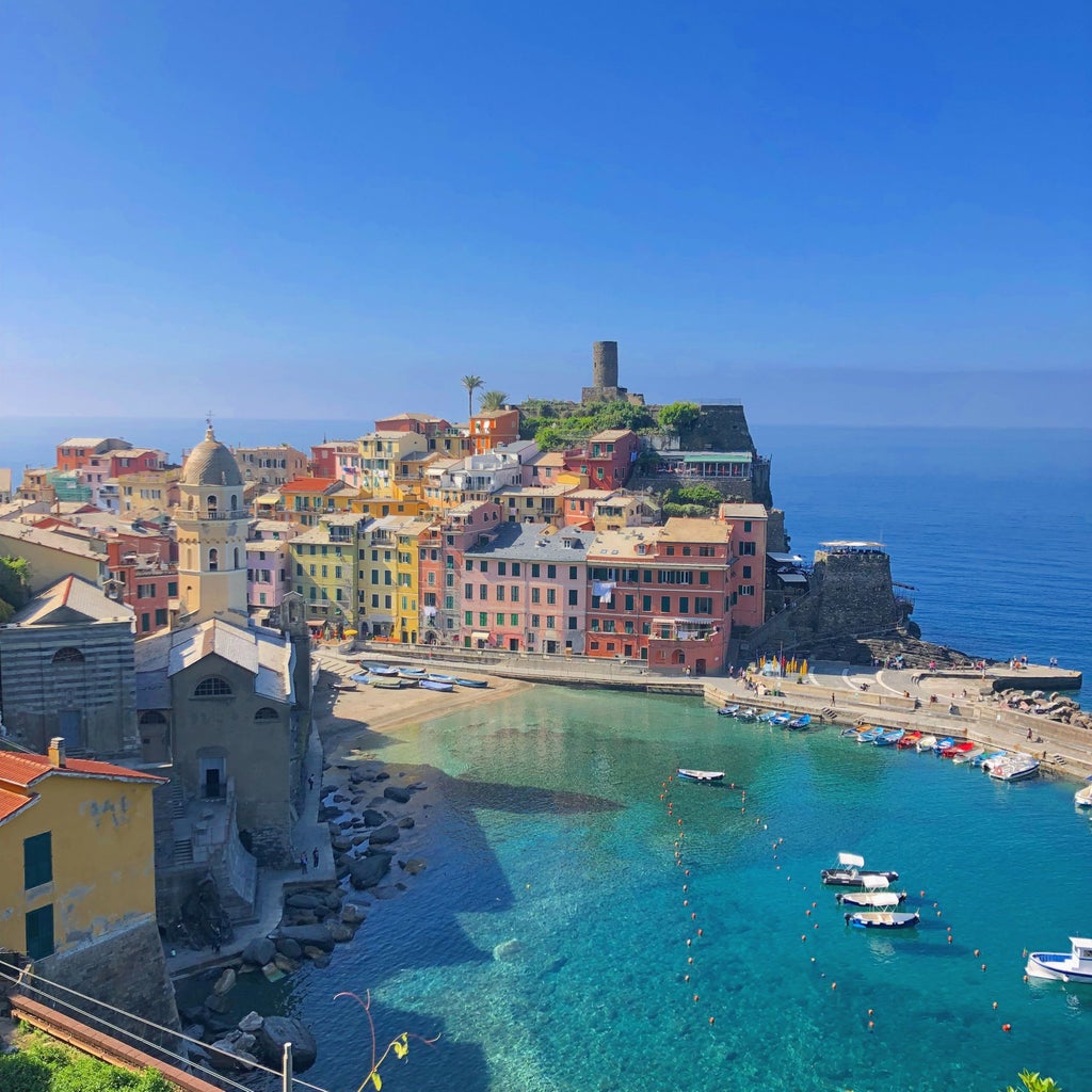 Colorful seaside houses nestled on dramatic cliffs overlooking the Mediterranean Sea in Cinque Terre's vibrant coastal village, Italy