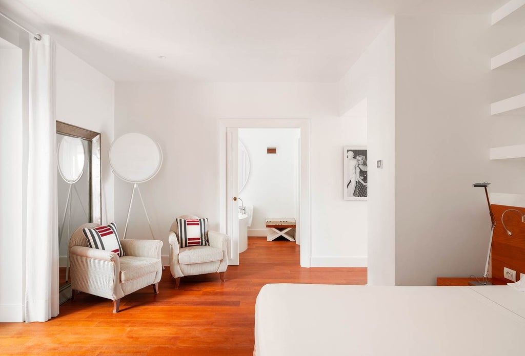 Elegant Vesuvio Suite at Bellevue Syrene, featuring luxurious white marble bathroom, panoramic coastal view, and sophisticated coastal Italian design elements