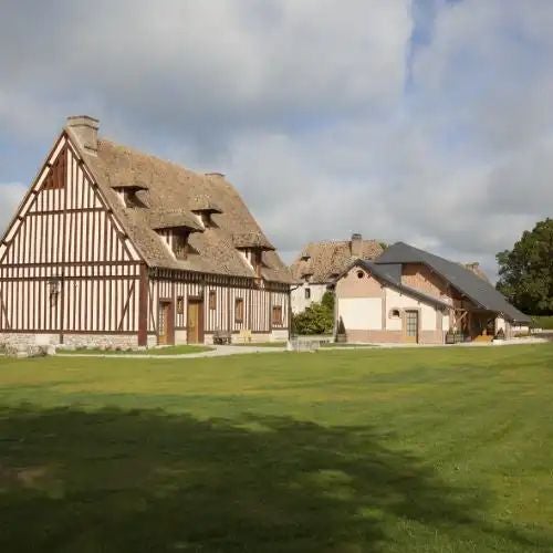 Elegant French countryside manor with stone facade, manicured gardens, and ivy-covered walls, showcasing timeless luxury and rustic charm near Normandy.