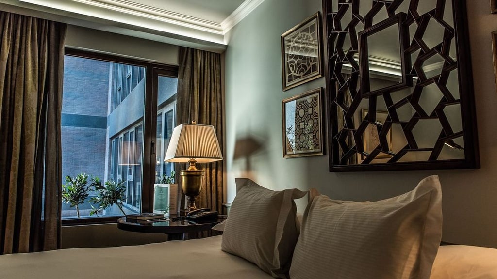 Elegant modern hotel facade with glass windows, stone accents and ornate lighting in Santiago's historic Lastarria neighborhood