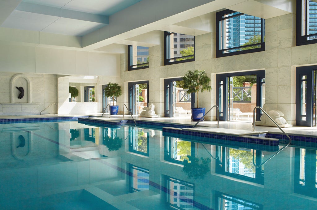 Elegant Four Seasons Atlanta hotel exterior featuring glass facade, ornate classical columns and grand entrance with luxury vehicles