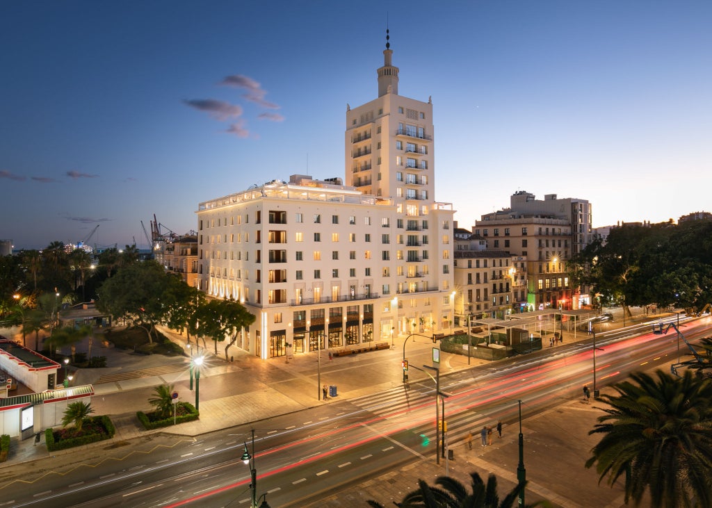 Elegant rooftop pool and lounge area at Only You Malaga hotel, with modern white sunbeds facing panoramic views of the Mediterranean Sea.