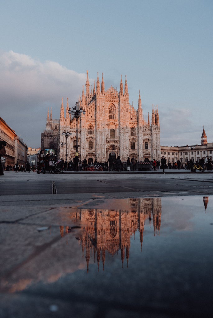 Elegant Galleria Vittorio Emanuele II in Milan featuring ornate glass dome ceiling, luxury boutiques and mosaic marble floors