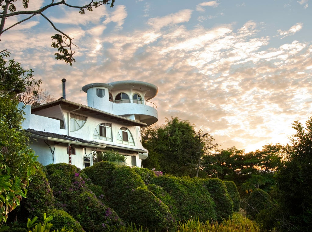 Luxurious eco-lodge nestled in lush Costa Rican mountains, featuring white-washed villa architecture surrounded by coffee plantations