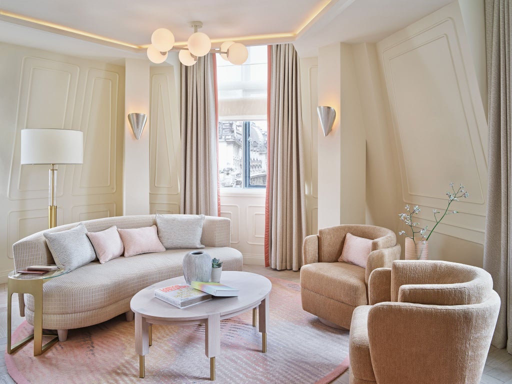 Luxurious loft suite at One Aldwych hotel with modern design, plush bedding, expansive windows, and sophisticated city-inspired decor in neutral tones