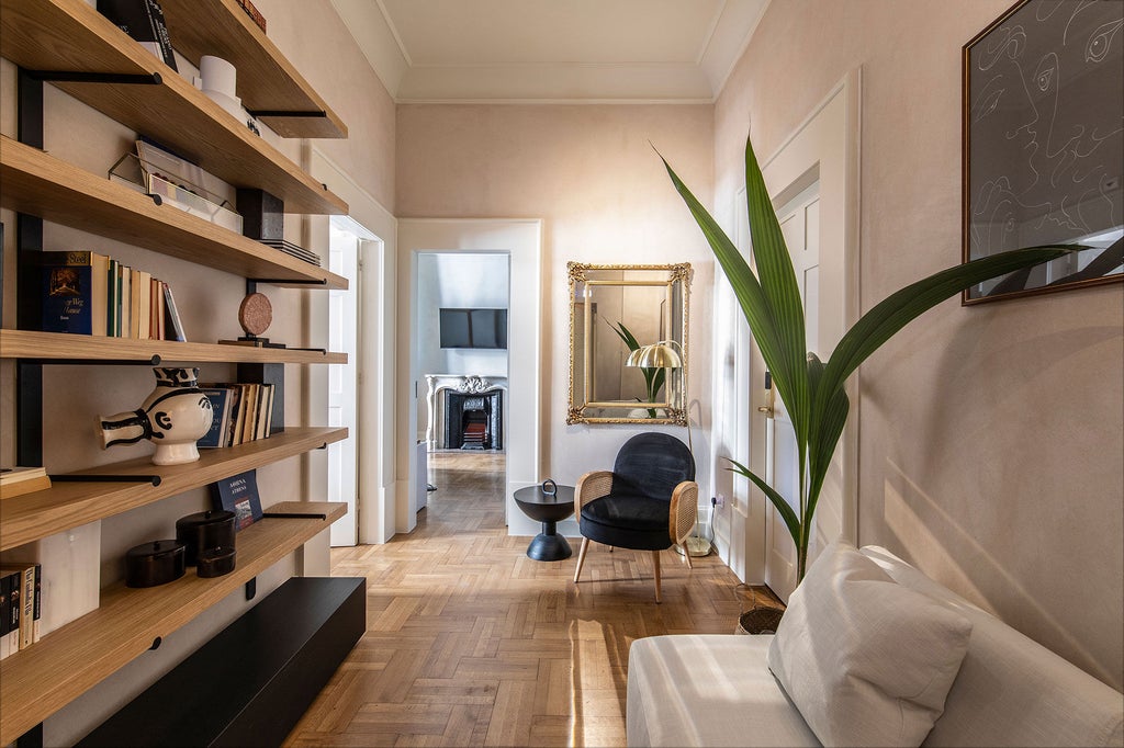 Elegant boutique hotel suite in Athens featuring vaulted white ceiling, ornate chandelier, antique furnishings and French balcony doors