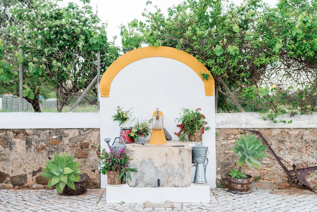 Rustic Portuguese stone cottage with traditional wooden veranda, surrounded by lush green hills, elegant outdoor seating with warm sunset lighting