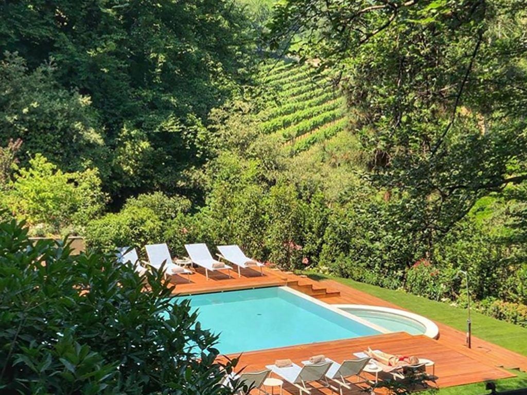 Elegant L'Albereta luxury resort nestled in Lombardy's rolling hills, featuring stone architecture, manicured gardens, and panoramic Franciacorta vineyard views