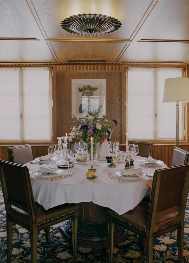 Elegant 18th-century Parisian boutique hotel façade with neoclassical architecture, ornate windows, and soft cream-colored exterior in soft evening light