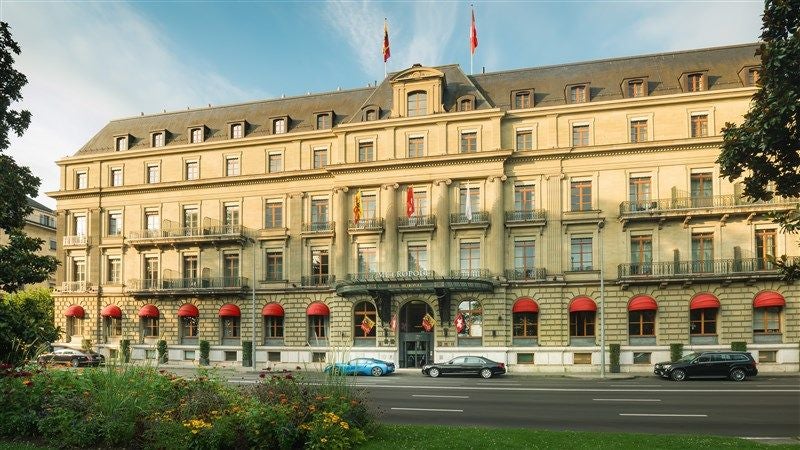 Elegant 19th-century luxury hotel in Geneva with neoclassical architecture, featuring ornate Belle Époque façade and lakefront location