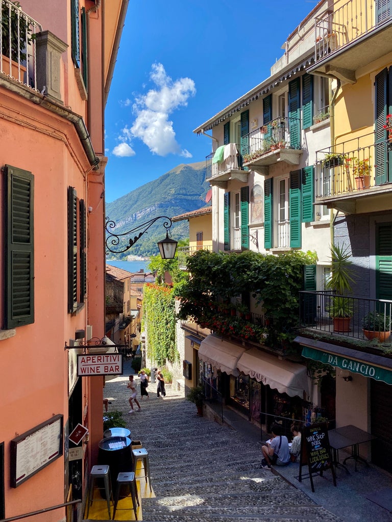 Historic lakeside villas and luxury estates nestled along the emerald waters of Lake Como, backed by mist-covered Italian Alps