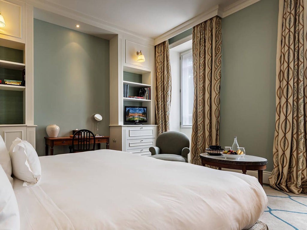 Elegant marble-clad bathroom with classic white vanity, gold fixtures, and plush white towels in luxurious Vidago Palace Hotel's Superior Room, Portugal