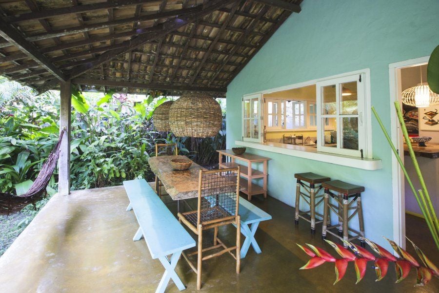 Luxurious wooden-paneled suite at UXUA Casa Hotel and Spa, featuring warm lighting, rustic Brazilian decor, and elegant minimalist design with natural textures