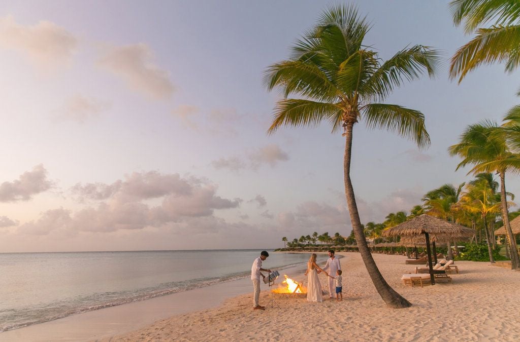 Luxurious beachfront resort with pristine white sand, turquoise Caribbean waters, and elegant palm-lined villas at a secluded Antigua island retreat