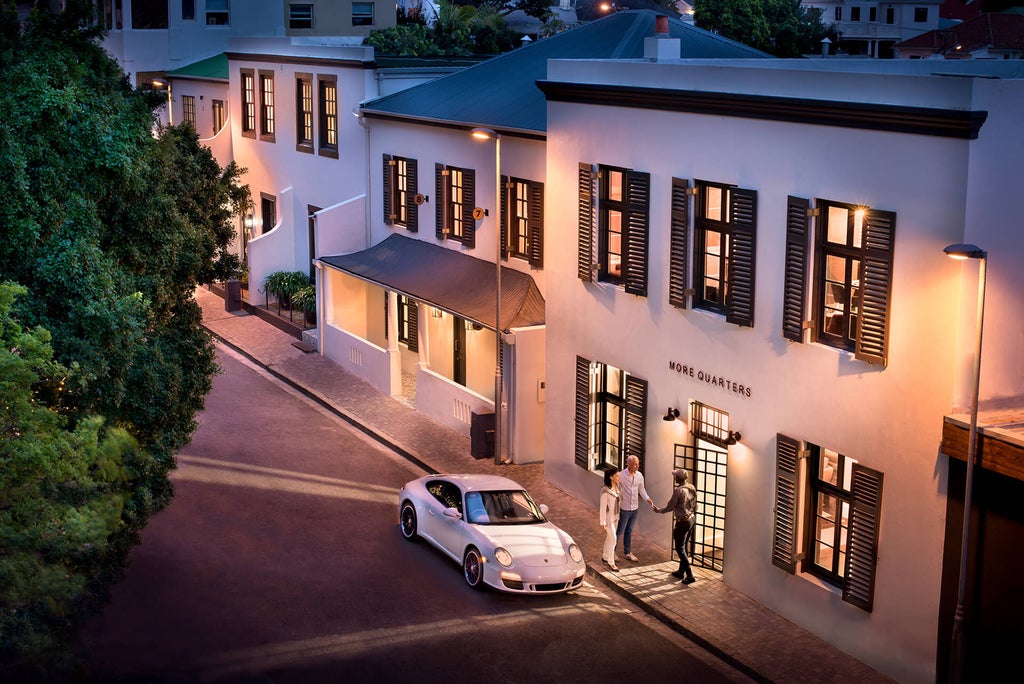 Elegant boutique hotel with white colonial architecture, palm trees and manicured gardens in Cape Town's upscale residential district