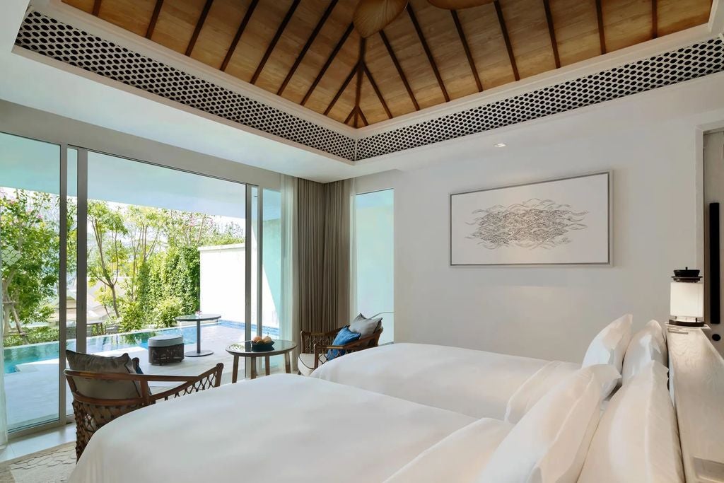 Luxurious twin suite with private infinity pool overlooking turquoise Andaman Sea, featuring modern decor and floor-to-ceiling windows