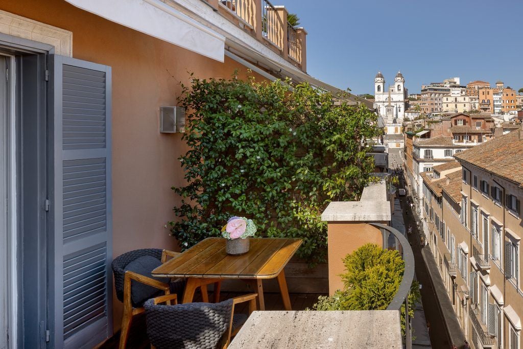 Luxurious Studio Deluxe room in Rome featuring elegant contemporary design, private terrace overlooking historic cityscape with soft neutral palette