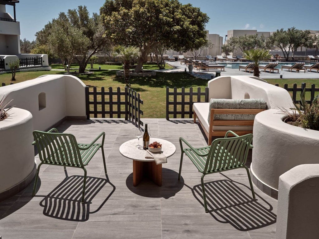 Spacious luxury king room at scenset beachfront resort, featuring modern decor, expansive terrace overlooking azure Mediterranean waters and lush greenery