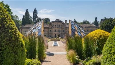 Luxurious three-story Georgian manor hotel with manicured gardens, stone facade, and elegant exterior set in scenic Yorkshire countryside landscape