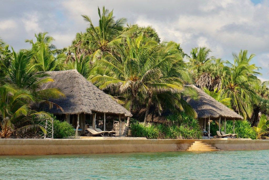 Elegant beachfront villa with thatched roof and private terrace overlooking pristine white sand beach and turquoise Indian Ocean waters