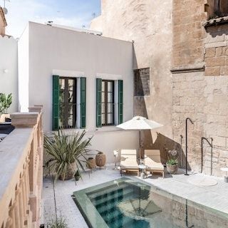 Luxurious boutique hotel in Barcelona's Gothic Quarter, featuring elegant white facade, modern design, and charming Mediterranean architectural details