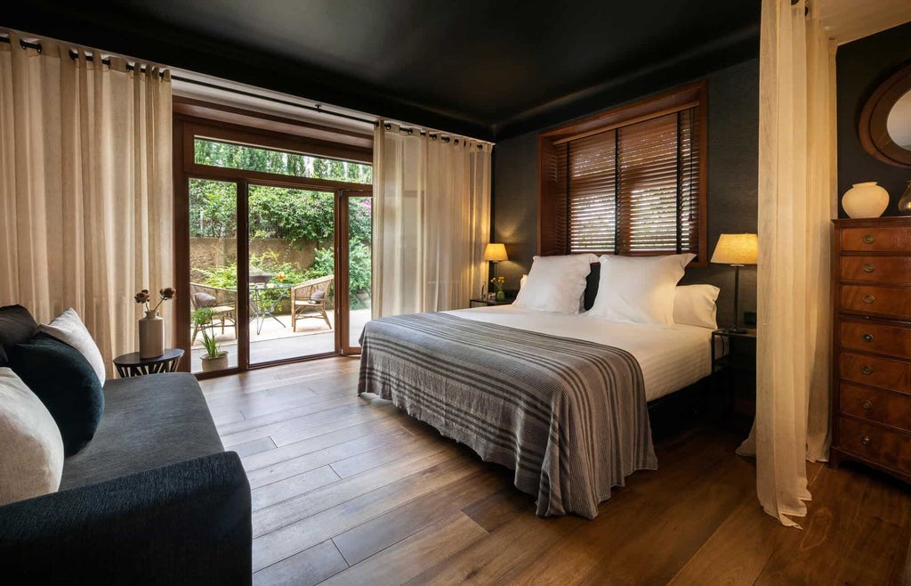 Elegant superior hotel room with private terrace, featuring modern decor, plush bedding, and warm wood accents overlooking scenic Spanish landscape